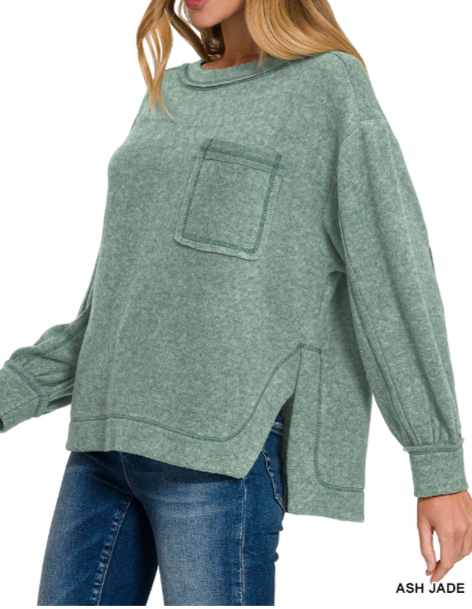 Green sweater with a pocket worn by a person on a white background